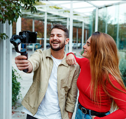 man shooting a video with gimbal with woman to upload to social networks. concept influencers
