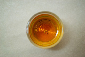 Glass with cognac top view on a light background