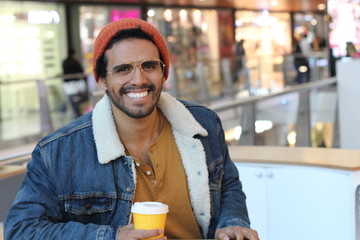 Hipster holding disposable coffee cup 