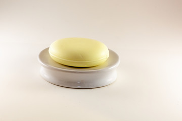 Handmade yellow soap on white soap disk