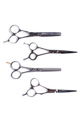 Set of hair cutting shears on white background. Group of hairdressing scissors, top view. Professional equipment for beauty salon.