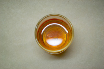 Glass with cognac top view on a light background