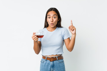 Young mixed race indian holding a tea cup having some great idea, concept of creativity.