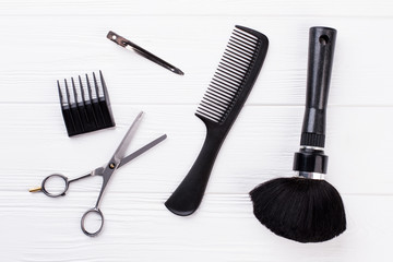 Set of hairdresser tools on white background. Scissors, comb and brush on wooden background. Main barbers tools.