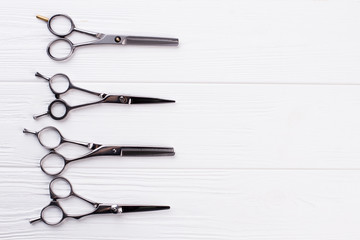 Steel hair dresser scissors for barber shop. Group of salon shears on white background. Space for text.