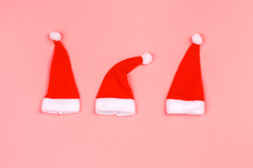 Santa Claus hat on a pink background. minimalistic christmas scandy background with empty place for text