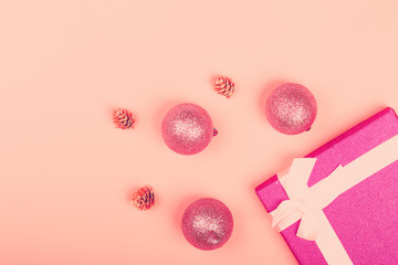 Pink glitter gift box with ribbon and Christmas toys on a pink background. minimalistic christmas background with empty place for text