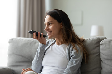 Woman spent time at home holding smartphone using voice messaging