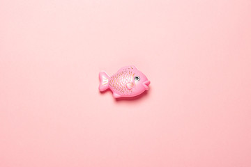 Plastic toy fish on a pink background. The concept of child development, proper nutrition, diet,...