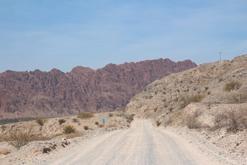 A road crosses Argentina's beautiful and colourful mountains