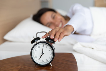 Woman woke up at seven o'clock turns off alarm