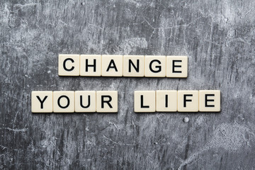 Fototapeta premium A motivational quote Change your life formed with tile letters 