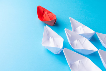 Leadership concept using red paper ship among white