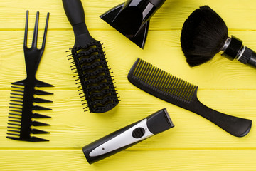 Set of hairdresser tools. Professional barber equipment on yellow wooden background.