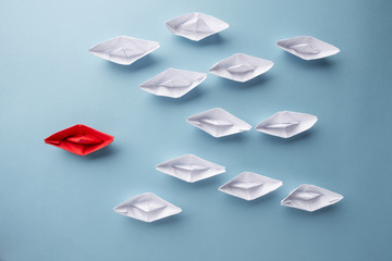 Leadership concept using red paper ship among white