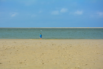 Sandy beach, sea, blue sky and a woman