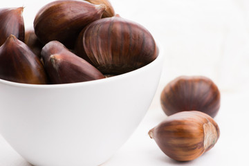 Bowl of chestnuts on a white background