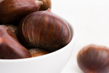Bowl of chestnuts on a white background