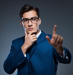 Businessman pressing virtual buttons on gray background