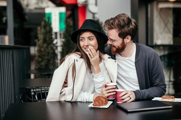 Happy couple enjoying hot drink during date