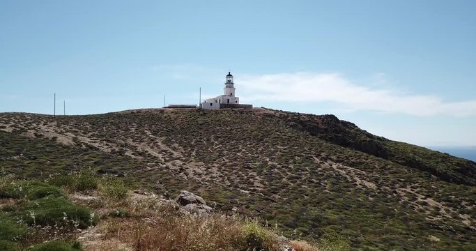 Astonishing aerial view of a girl and a lighthouse at a background.Drone zoom in