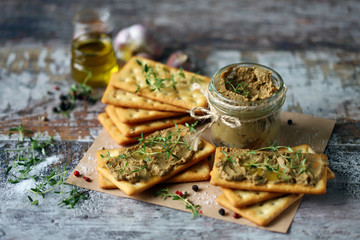 Selective focus. Homemade liver pate with cracker and microgreens.
