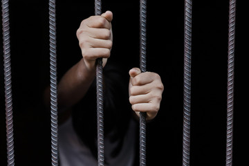child holding a steel cage in old iron bar. children prison and prisoner concept