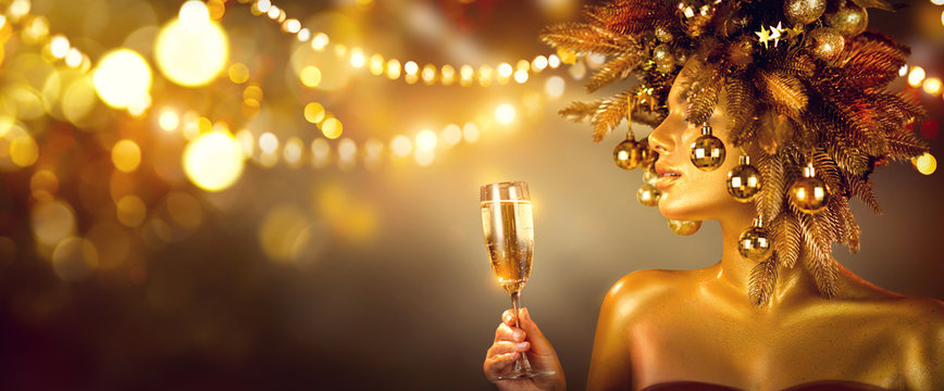 Beauty Glamour Golden Christmas Woman celebrating with champagne, wearing wreath decorated with baubles. Party, drinking sparkling wine, glowing holiday background. Xmas, New Year Holiday celebration