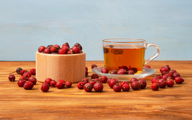 Rose hips.Dried rosehip berries with a cup of aromatic rosehip drink on a wooden background. Healing berries.