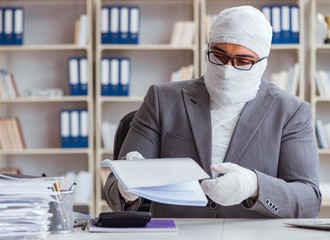 Bandaged businessman worker working in the office doing paperwor