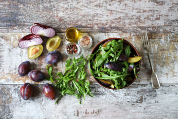 Fototapeta na wymiar Selective focus. Healthy salad with arugula and plum in a bowl.
