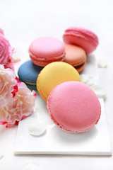 Different tasty macarons on white table