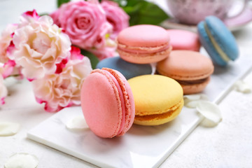 Different tasty macarons on white table