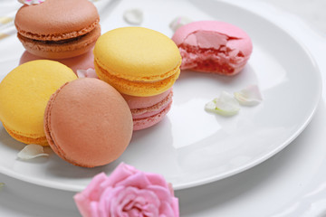Different tasty macarons on plate, closeup
