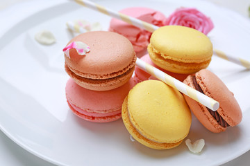 Different tasty macarons on plate, closeup
