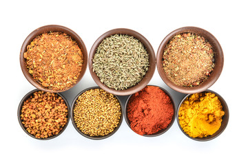 Bowls with different spices on white background
