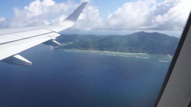 Aerial view out of an Etihad Airways Airbus A330-300s right window on final approach to Mahe island, Seychelles on a sunny day with few clouds in the sky.
