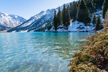 Lake with turquoise water surrounded by a mountain massif. Big Almaty lake in the mountains. Kazakhstan