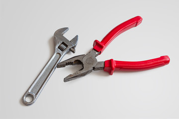 Wrench and pliers on white background