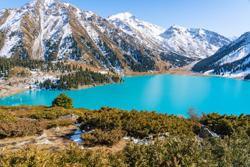 Lake with turquoise water surrounded by a mountain massif. Big Almaty lake in the mountains. Kazakhstan