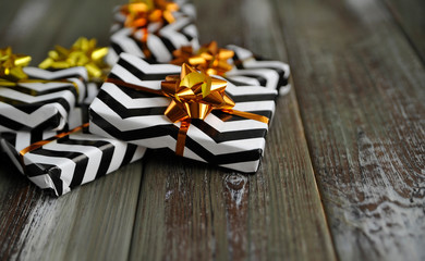 Christmas gifts with golden ribbons and bows on wooden background.