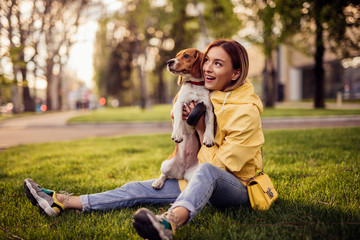 Woman and dog bonding in grass in park