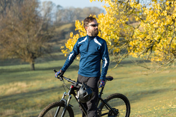 Cyclist in pants and fleece jacket on a modern carbon hardtail bike with an air suspension fork. The guy on the top of the hill rides a bike.