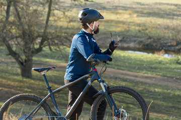 Obraz premium Cyclist in pants and fleece jacket on a modern carbon hardtail bike with an air suspension fork. The guy on the top of the hill rides a bike.