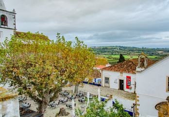 A top view of the town, Obidos in Portugal. Trees, houses, roofs, sky, clouds.