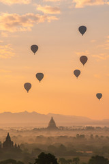 Fototapeta na wymiar Group of the hot air balloons flying over ancient pagoda in Bagan plain at dawn. Bagan now is the UNESCO world heritage site and the first kingdom of Myanmar.