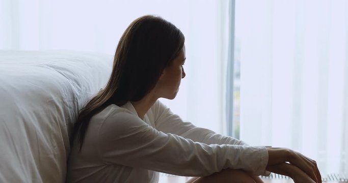 Sad depressed young lady sit alone on floor in bedroom