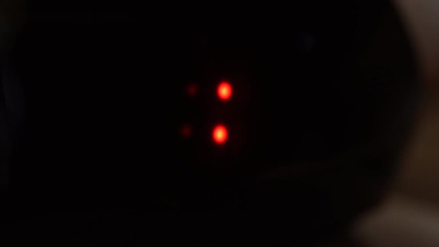 Close-up of black digital clock screen showing 21.00. Blinking red numbers on black background. Modern timer and neon light, electric device and modern technology