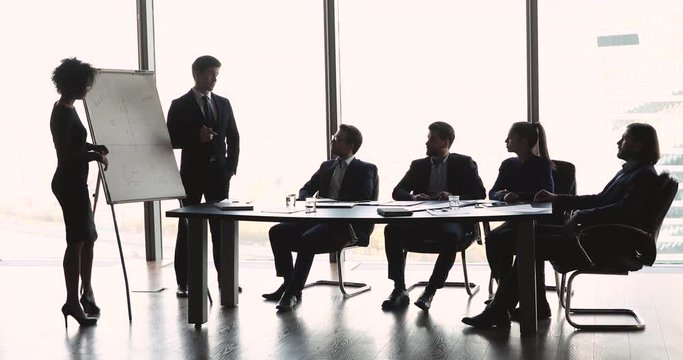 Two diverse professional coaches team give business presentation at meeting