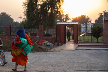 View of monk carrying the appliance and walk to temple in the evening with sun set.